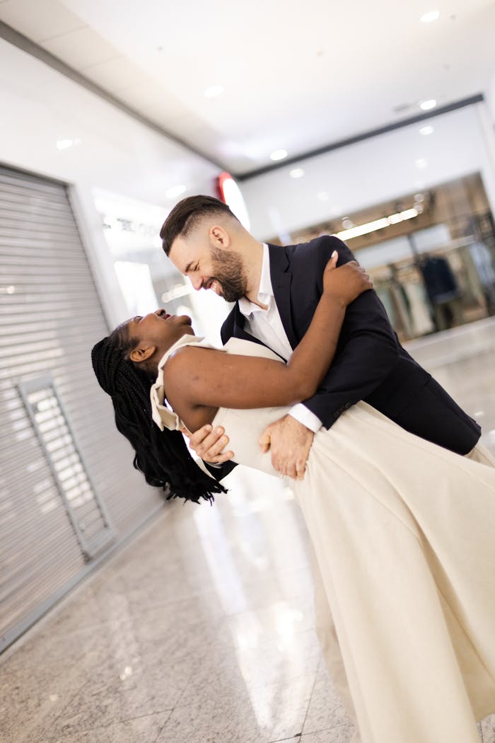 A joyful couple embracing and dancing indoors, capturing a loving moment.